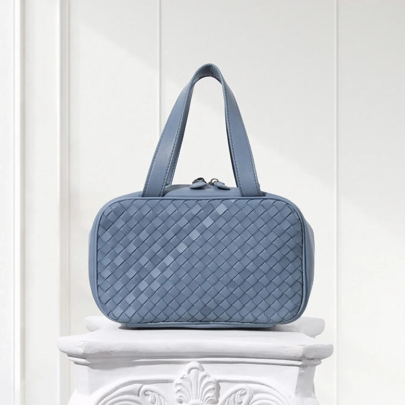 Front view of blue braided leather handbag for women – structured box tote design