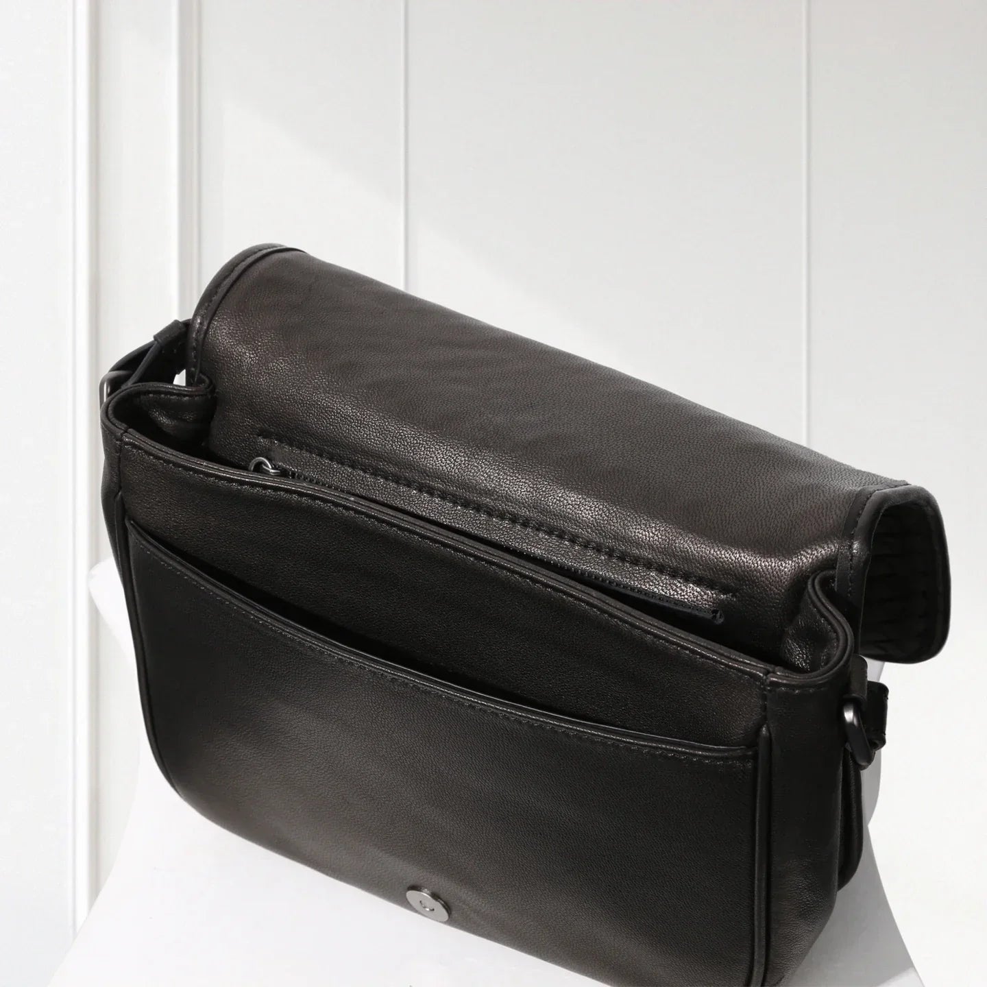 Black leather shoulder bag on a white background