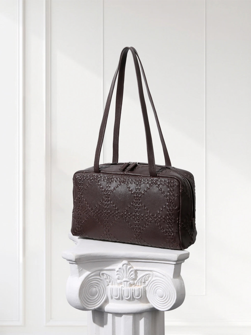 Brown premium leather bowling-style handbag with top zipper and adjustable shoulder strap