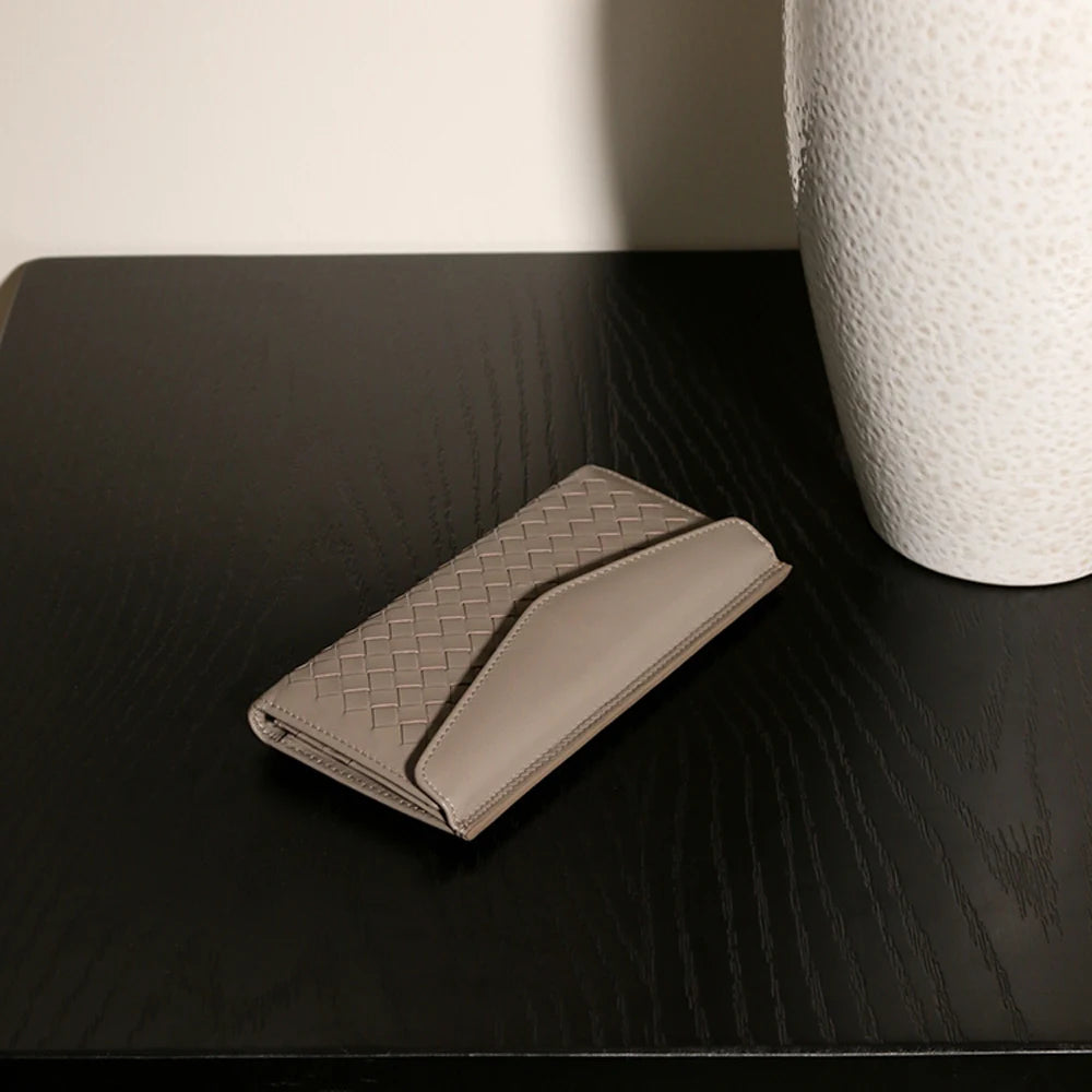 Experience the buttery softness of our Artisanal Sheepskin Woven Wallet. A slim bifold design featuring a secure coin purse and bill storage.