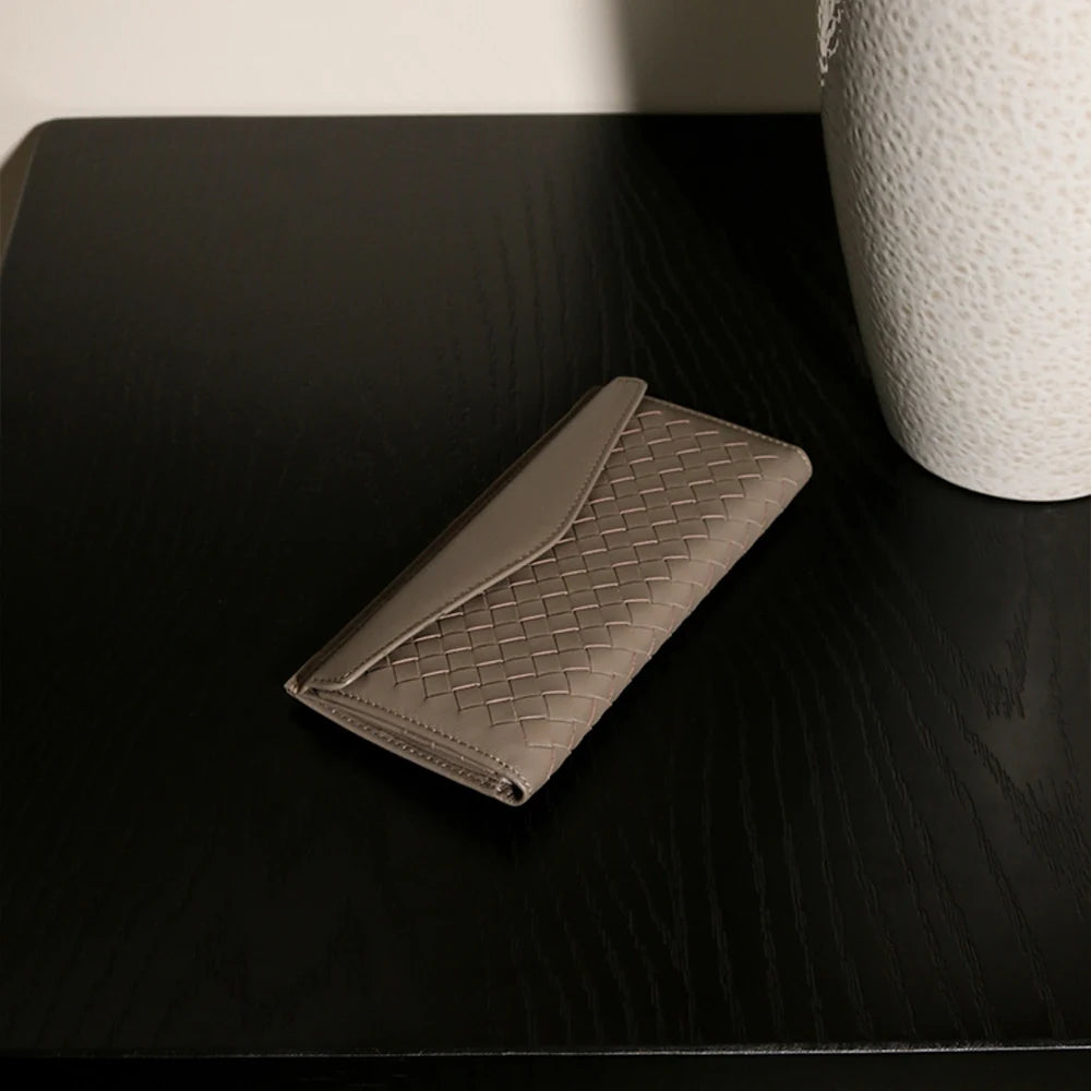 Experience the buttery softness of our Artisanal Sheepskin Woven Wallet. A slim bifold design featuring a secure coin purse and bill storage.