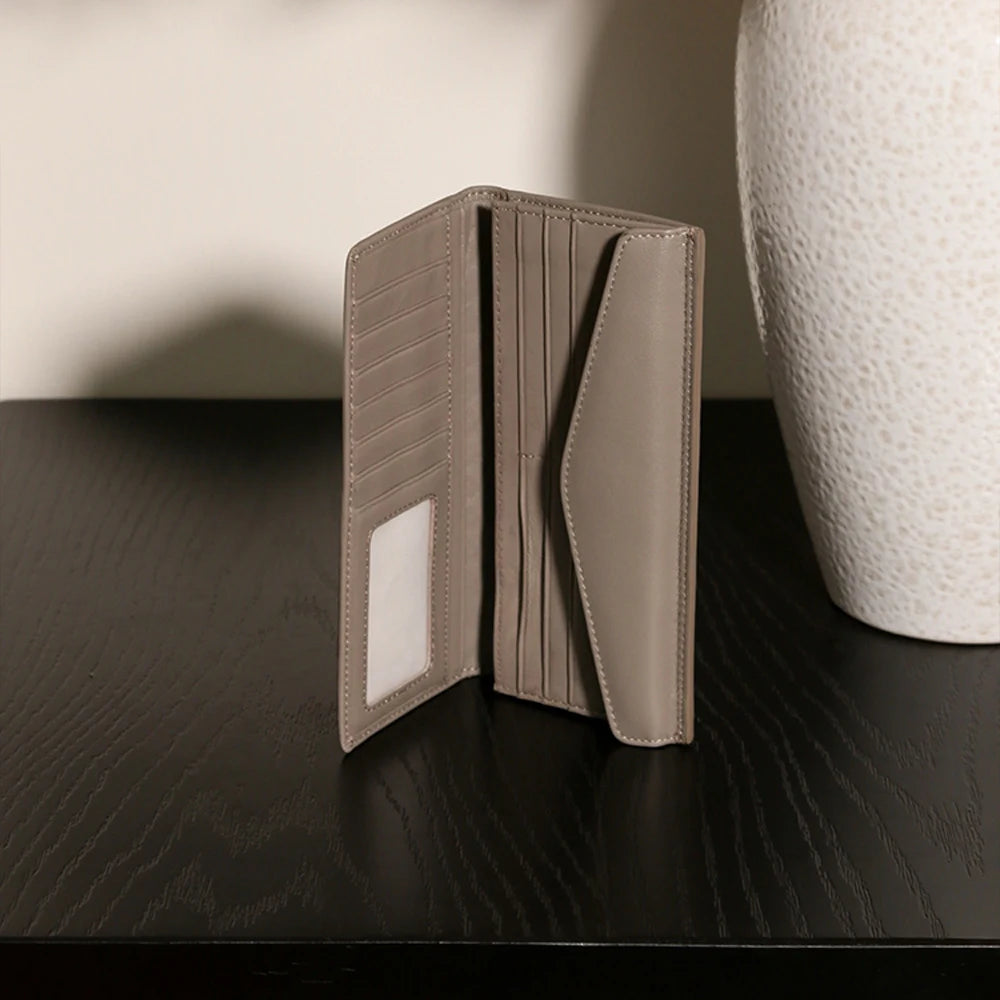 Experience the buttery softness of our Artisanal Sheepskin Woven Wallet. A slim bifold design featuring a secure coin purse and bill storage.