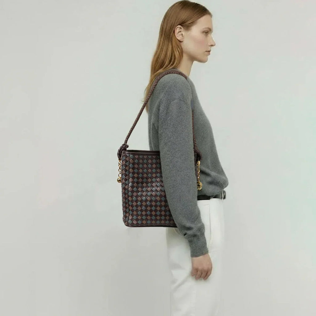 Woman carrying a patterned handbag on a plain background