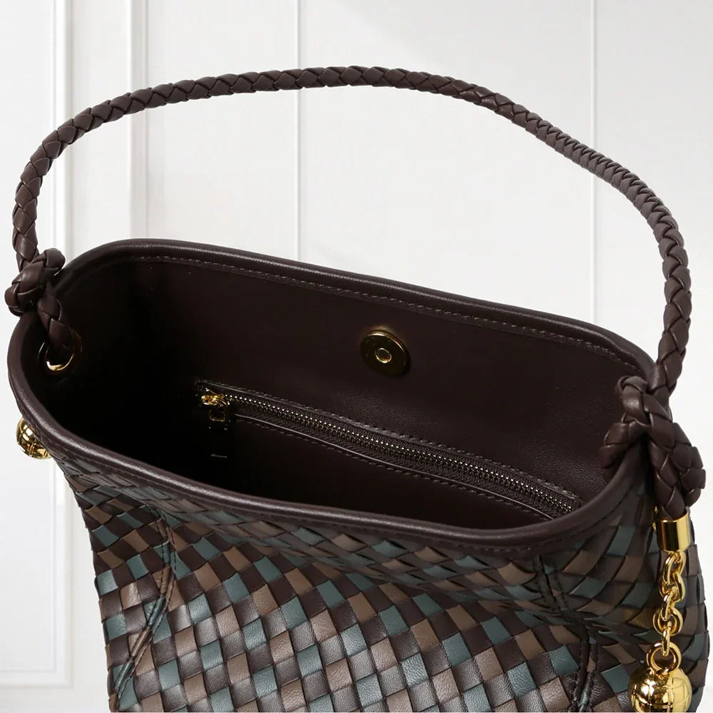 Elegant handwoven leather bucket bag in brown and blue tones with braided shoulder strap and gold-tone accents