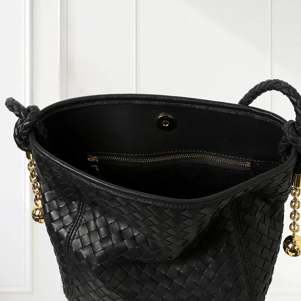 Elegant handwoven leather bucket bag in brown and blue tones with braided shoulder strap and gold-tone accents