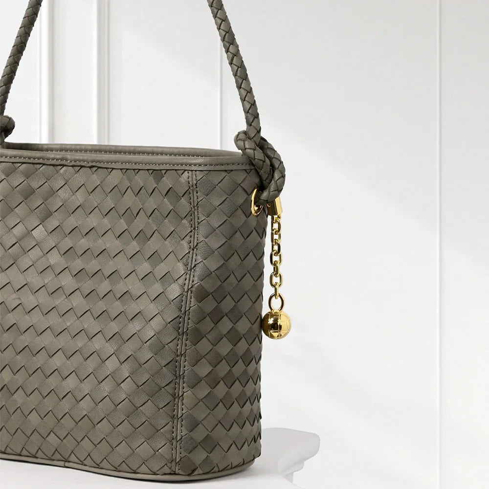 Elegant handwoven leather bucket bag in brown and blue tones with braided shoulder strap and gold-tone accents