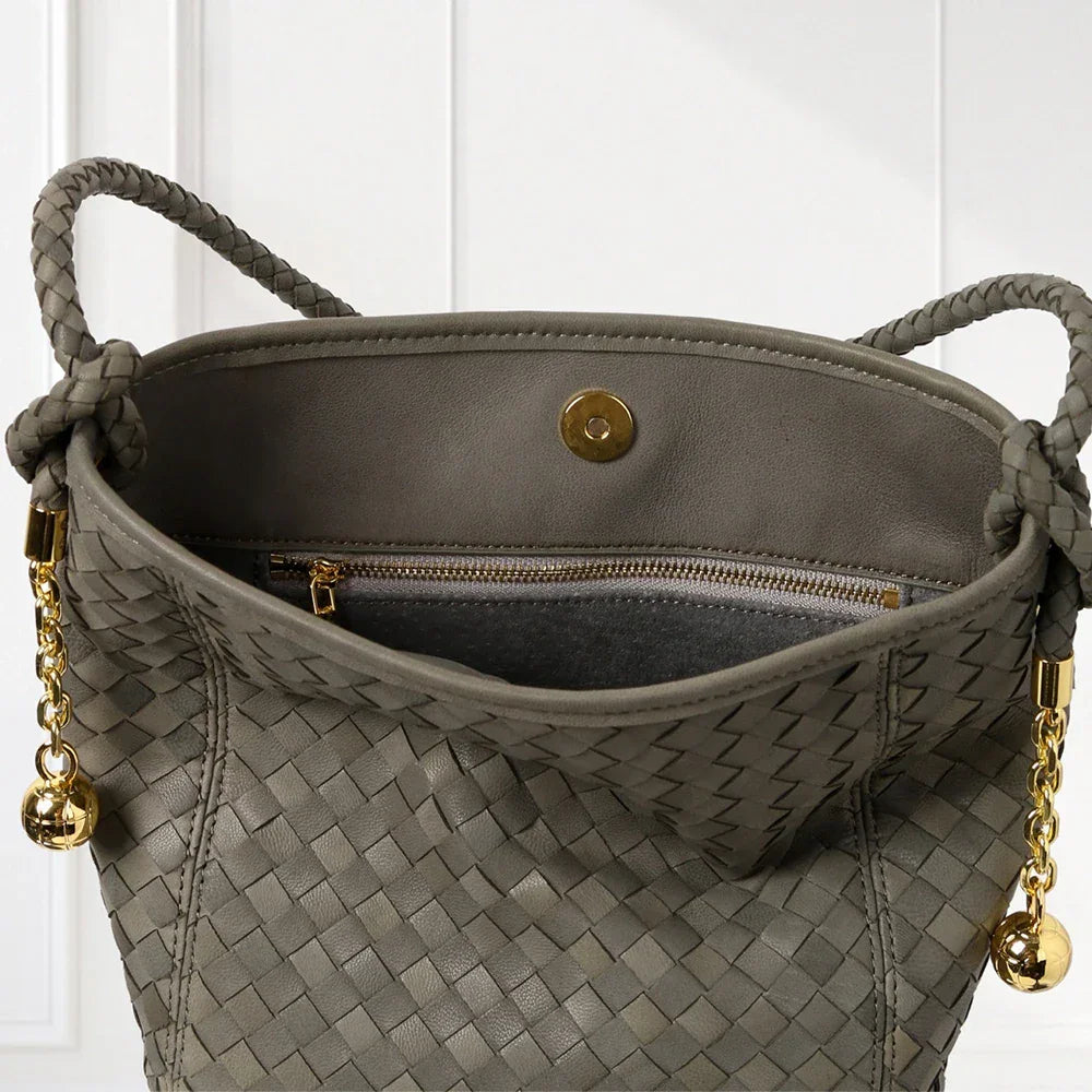 Elegant handwoven leather bucket bag in brown and blue tones with braided shoulder strap and gold-tone accents