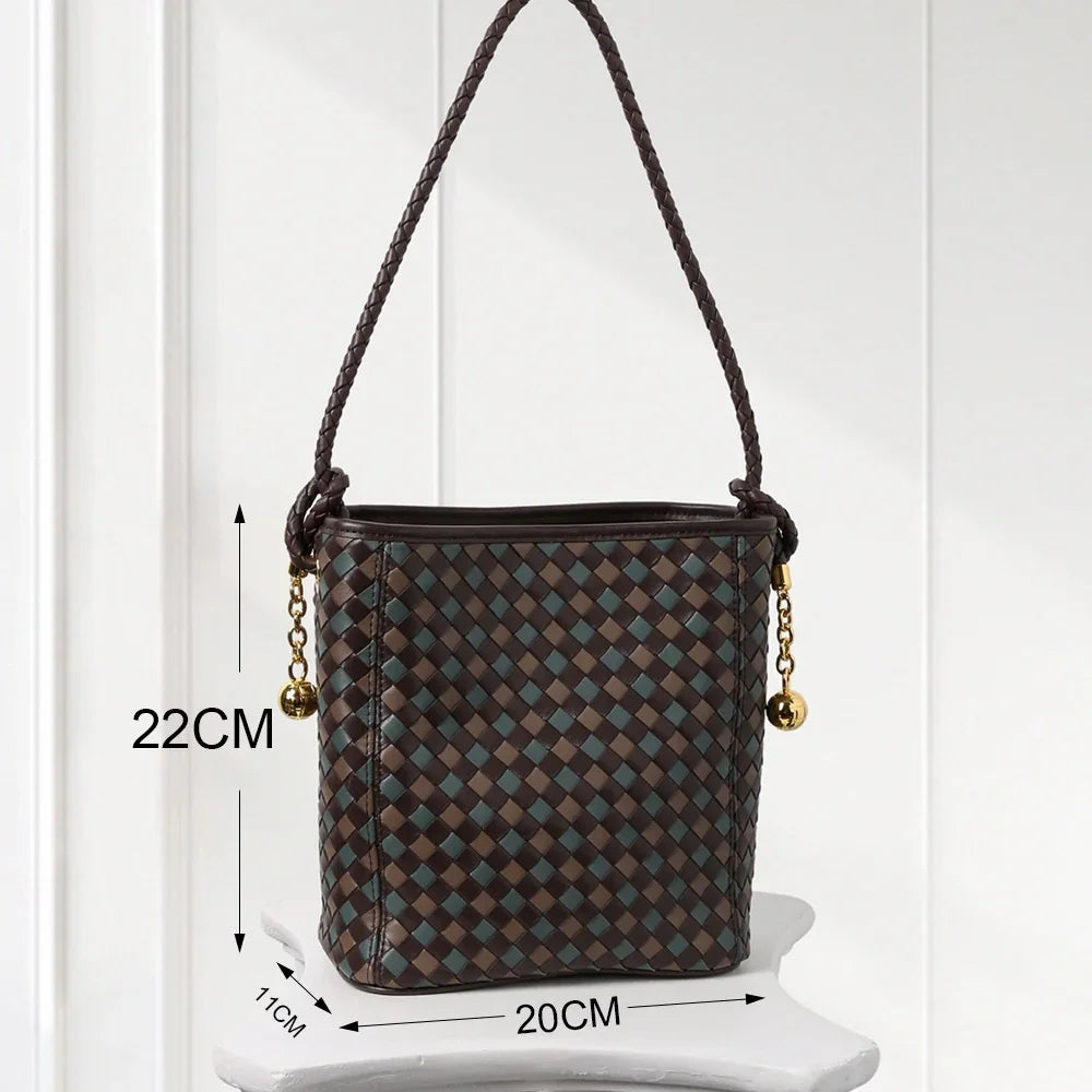 Elegant handwoven leather bucket bag in brown and blue tones with braided shoulder strap and gold-tone accents