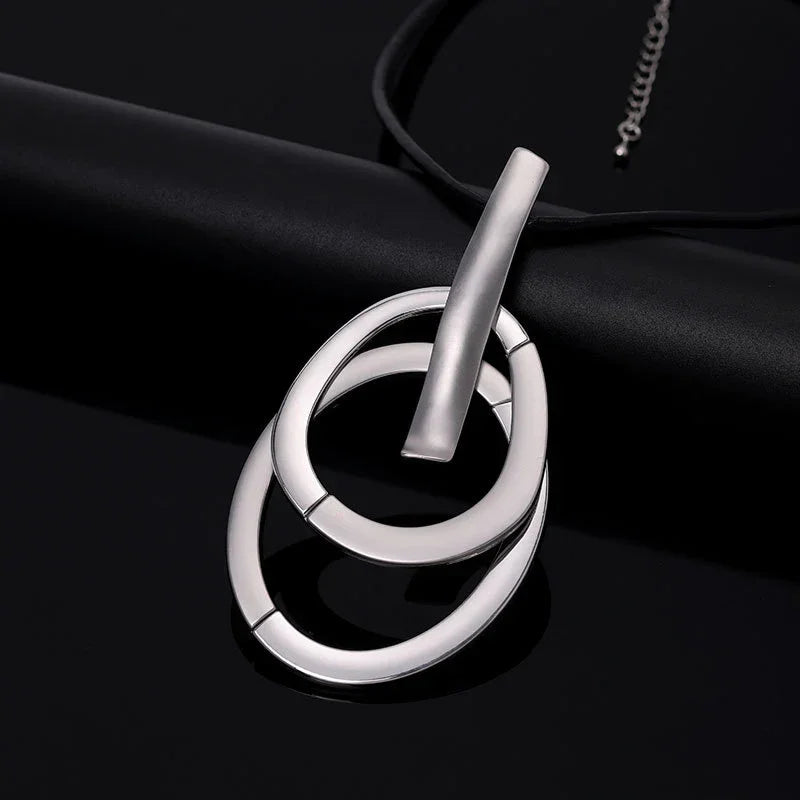 Woman wearing modern interlocking silver pendant necklace, minimalist contemporary jewelry | Civibuy wholesale USA