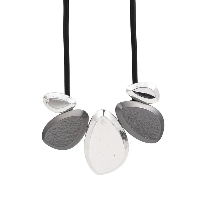 Textured and polished silver teardrop pendants on black rubber cord, geometric statement necklace | Shop Civibuy near New York
