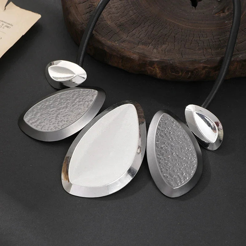 Silver geometric statement necklace with rubber cord on neutral background, minimalist art-inspired jewelry | Civibuy jewelry near New York