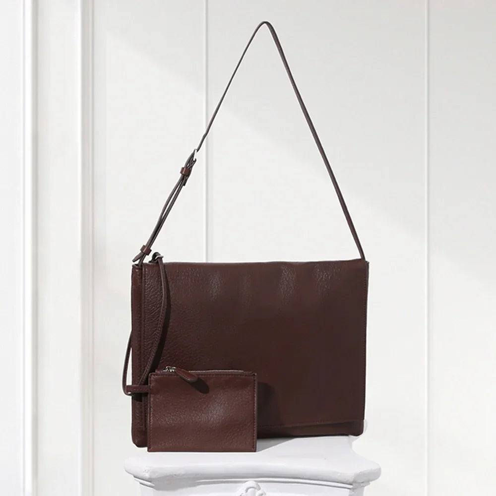 Minimalist dark brown lambskin messenger bag with front flap, adjustable shoulder strap, and slim rectangular design for women.