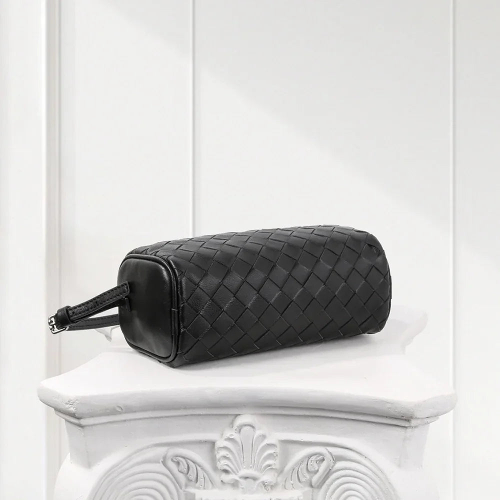 Close-up of black woven leather handbag showing fine weave pattern and durable zipper detail.