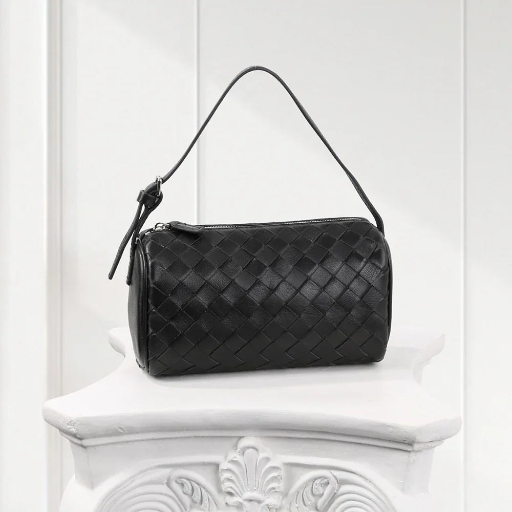 Front view of black woven leather handbag with structured top handle, luxury women’s shoulder bag.