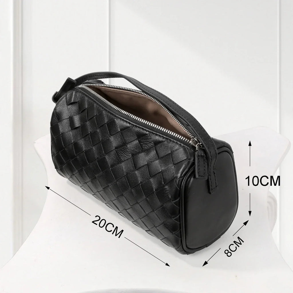 Side view of elegant black woven leather handbag, handcrafted weave design with smooth finish.