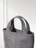 Gray handbag with geometric pattern on a white background