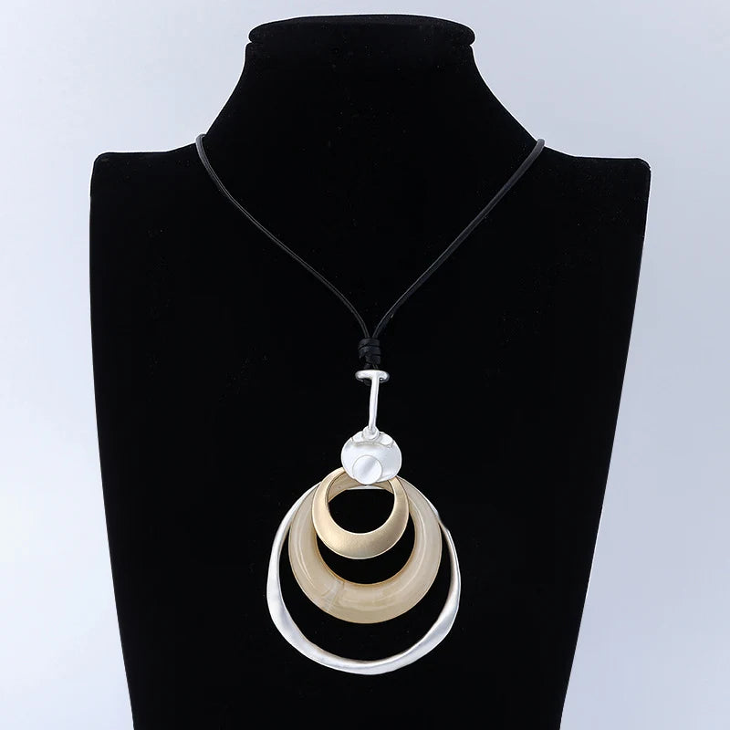 Necklace with a pendant on a black mannequin against a light gray background