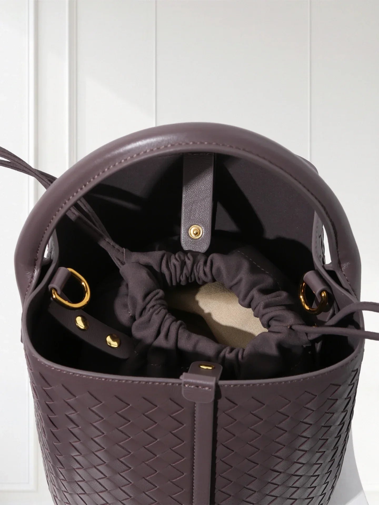 Handcrafted brown woven leather bucket tote with green suede inner bag, 100% lambskin