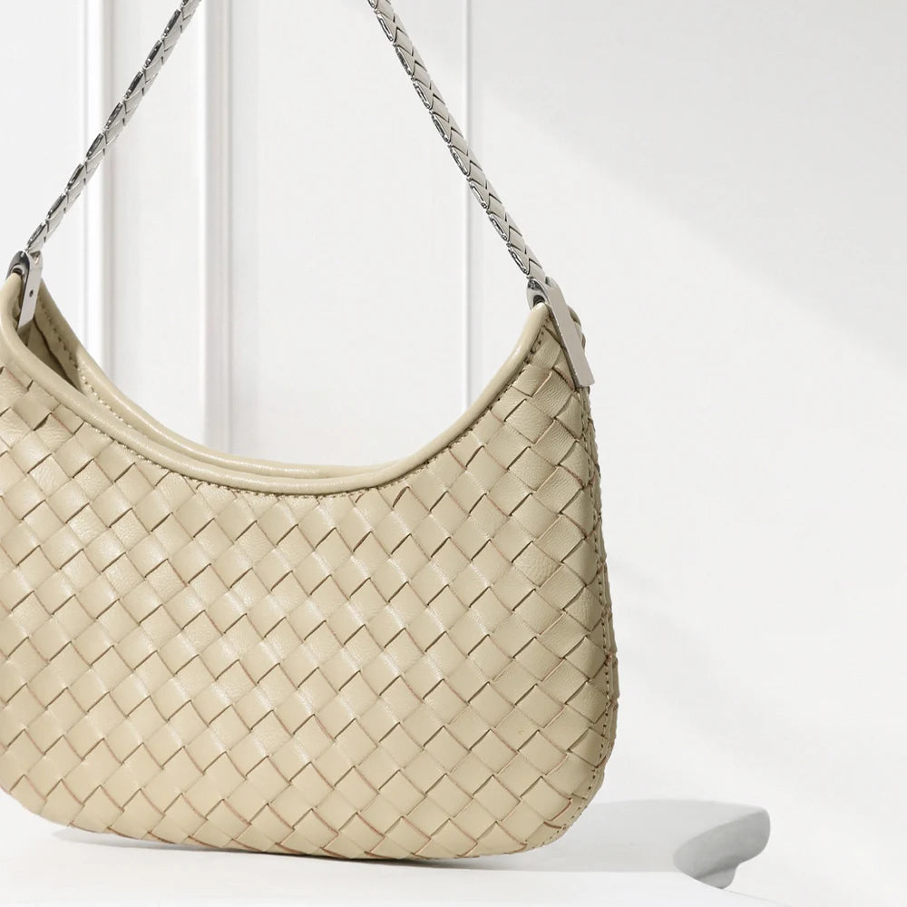 Beige woven handbag with a braided handle on a white background