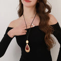 Elegant Teardrop Pendant Necklace with Golden Accent & Red Gemstone