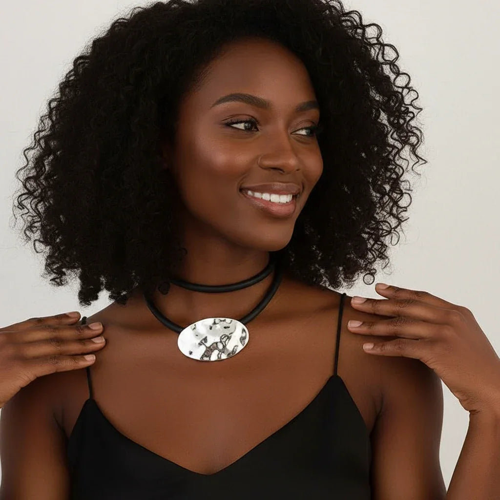 Textured silver oval pendant on black rubber cord, abstract modern jewelry design | Shop Civibuy near New York