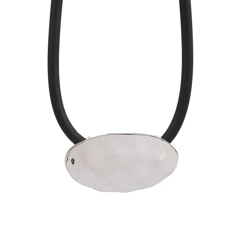 Necklace with a silver pendant on a black cord against a white background
