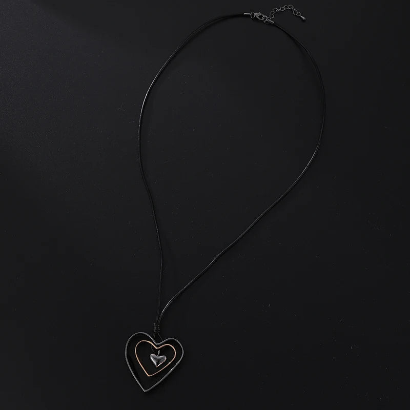 Black heart-shaped pendant necklace on a black background