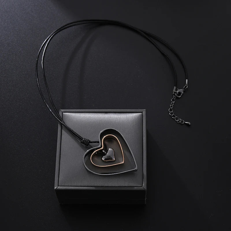 Necklace with a heart-shaped pendant on a black box against a dark background