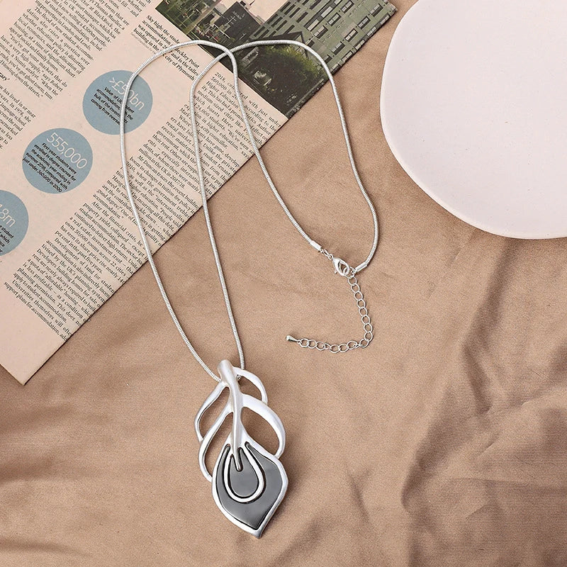 Silver necklace with a unique pendant on a textured surface