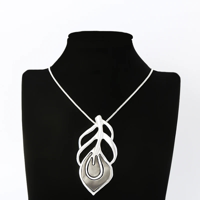 Necklace with a silver pendant on a black mannequin against a white background