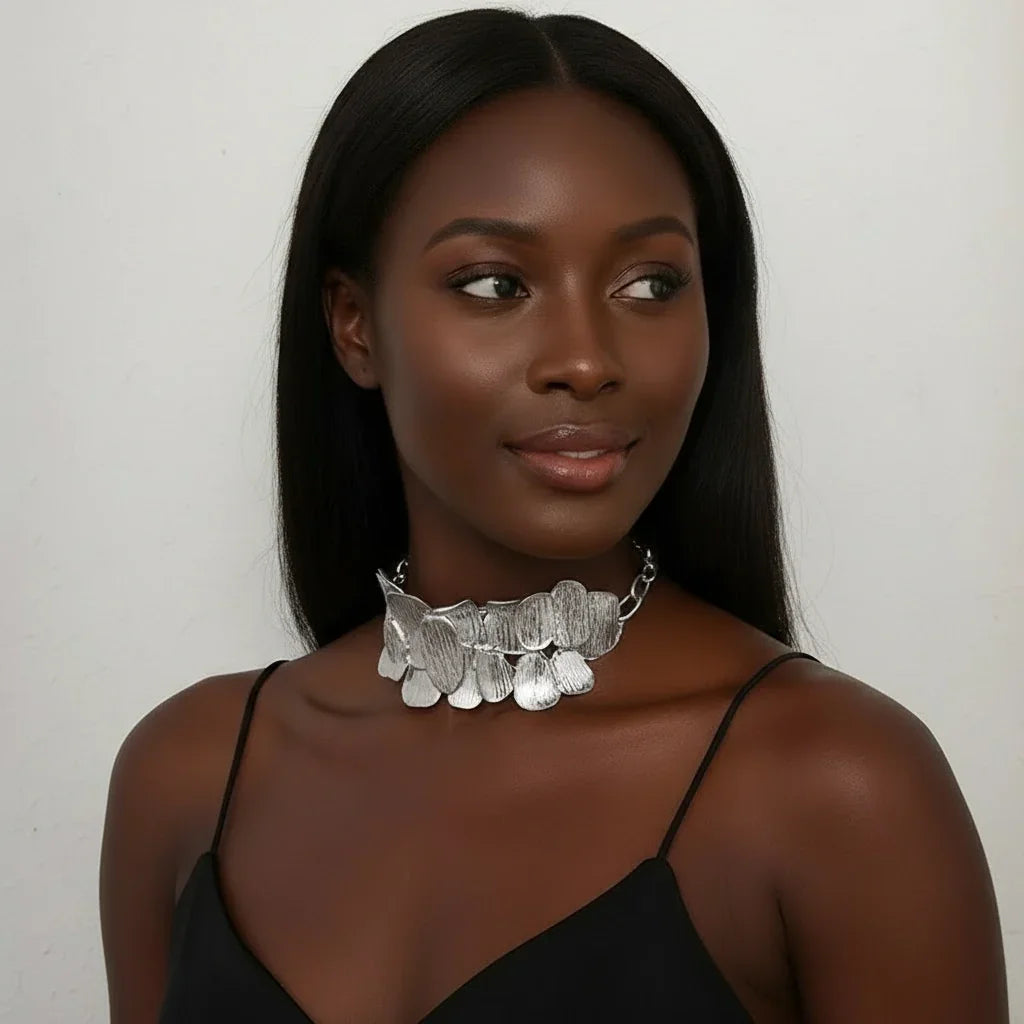 Woman wearing a silver necklace against a plain background