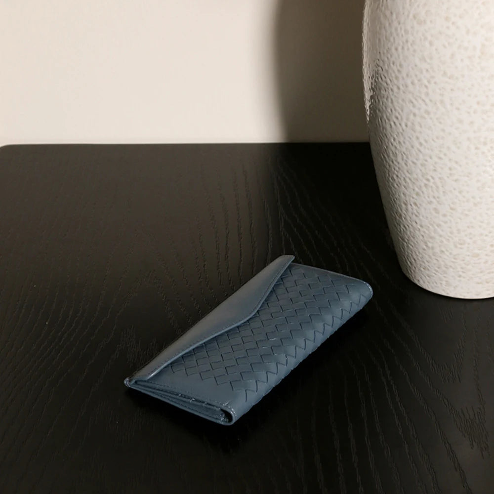 Experience the buttery softness of our Artisanal Sheepskin Woven Wallet. A slim bifold design featuring a secure coin purse and bill storage.