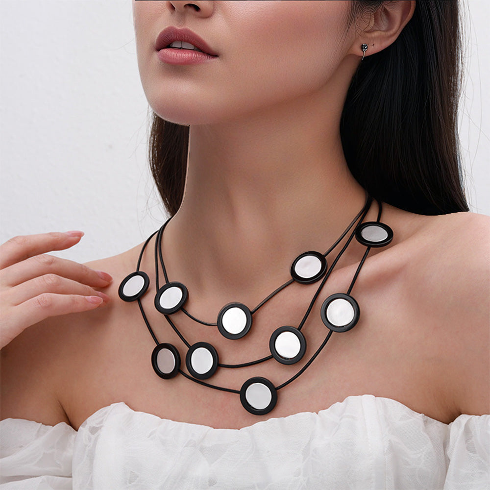 Elegant black multi-layered necklace with circular mirror accents. A bold statement piece for women’s fashion jewelry