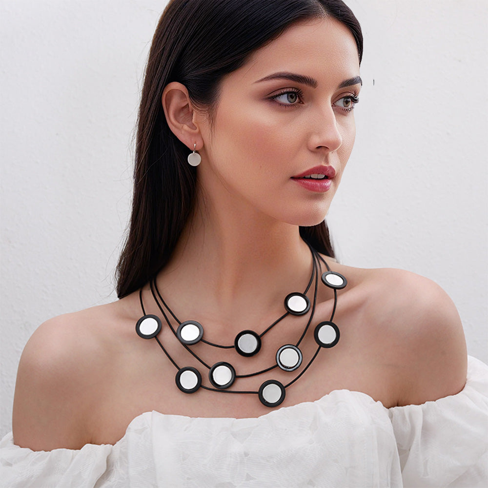 Elegant black multi-layered necklace with circular mirror accents. A bold statement piece for women’s fashion jewelry