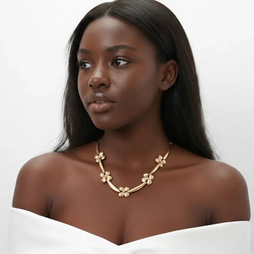 Woman wearing a gold necklace against a white background