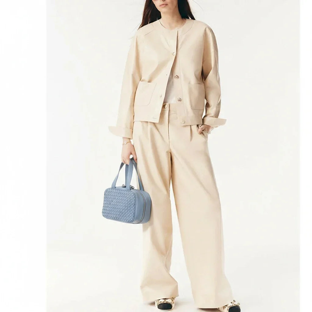 Woman holding blue woven leather handbag – elegant handmade purse for daily use